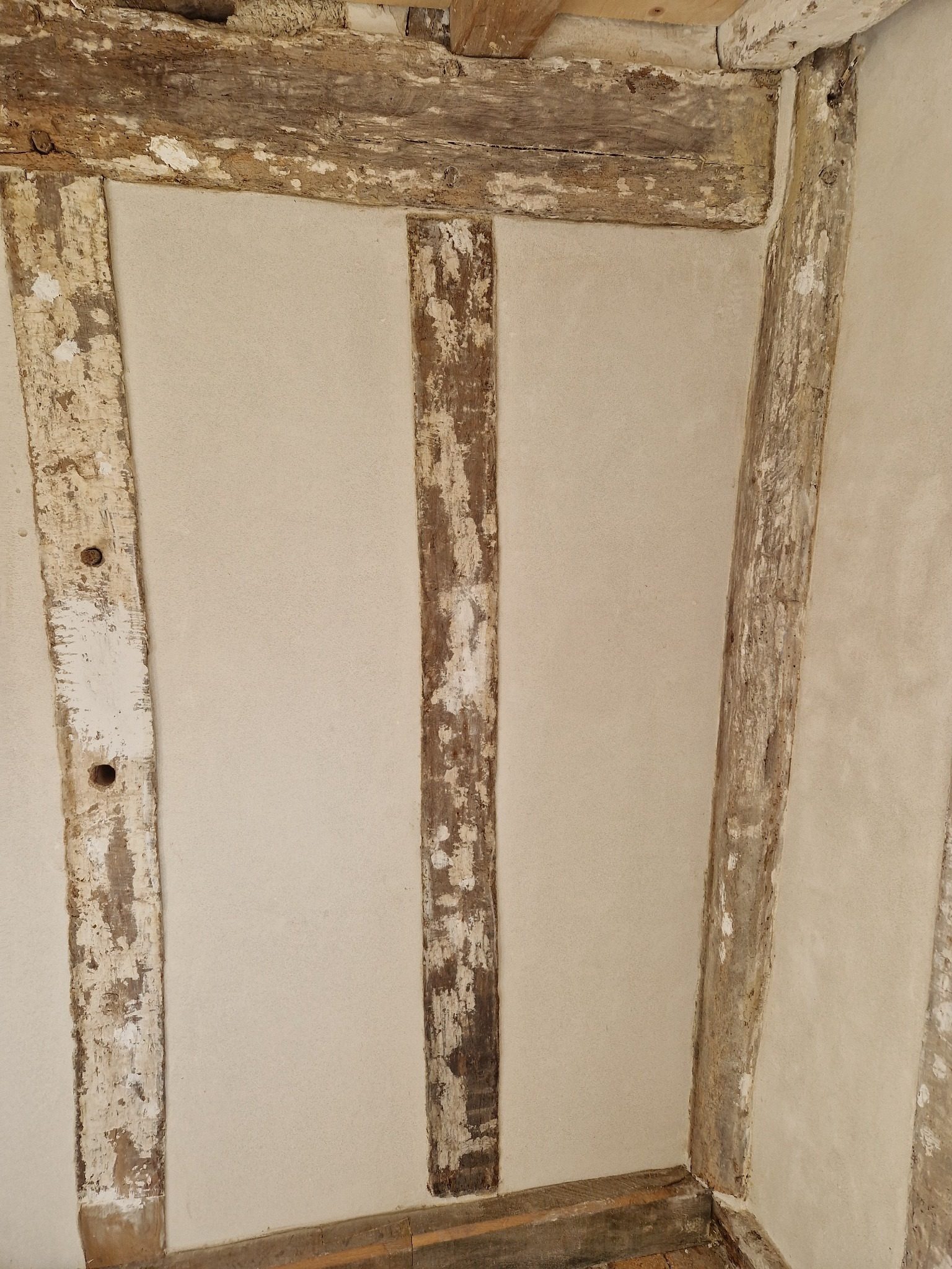 Completed internal lime plaster between original timber framing